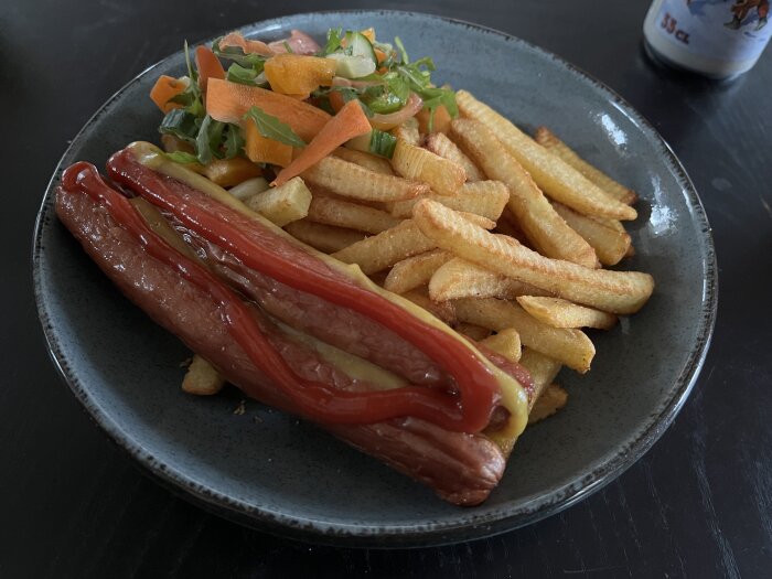 Tallrik med korv med bröd, pommes frites och sallad, toppat med ketchup och senap.
