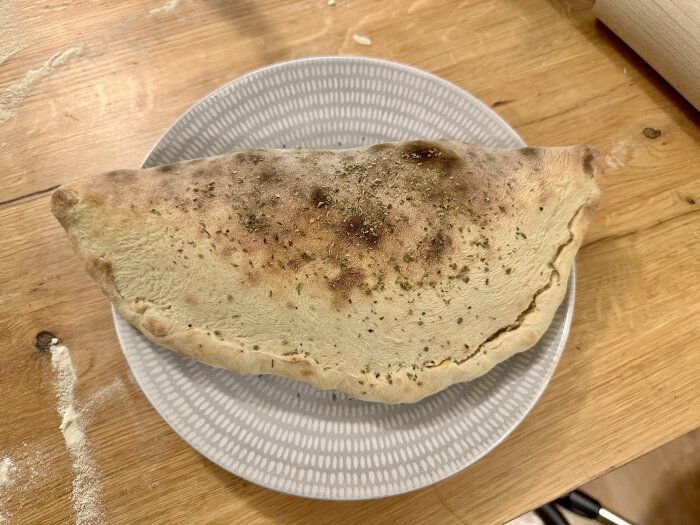Inbakad pizza på tallrik, bakad i vanlig ugn med köpedeg.