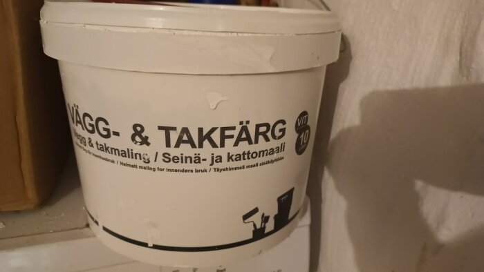 Vit hink med vägg- och takfärg, okänd tillverkare. Texter på flera språk, volym 10 liter. Använd som grundmålning, nu ur sortiment.