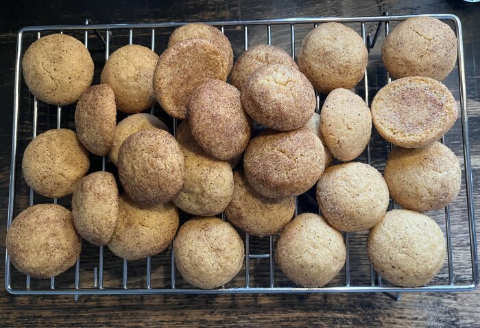 Snickerdoodle-kakor med kanel och vanilj, placerade på ett galler för avsvalning. Kakorna är mjuka och runda.