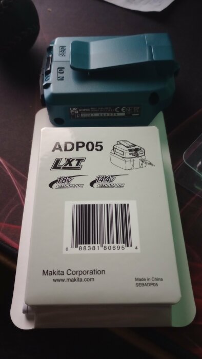 Makita adaptermodell ADP05 ligger på ett bord, används för att omvandla maskinbatterier till powerbanks, märkt med 18V och 14.4V lithium-ion.