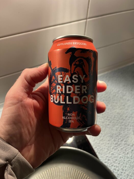 En hand håller i en burk med alkoholfri IPA från Gotlands Bryggeri, märkt "Easy Rider Bulldog", mot en bakgrund av kakel och ljus yta.