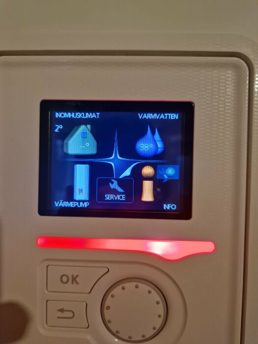 Display på värmepump med temperaturinställningar och ikoner för inomhusklimat och varmvatten, temperatur visas som 2°C och 38°C.