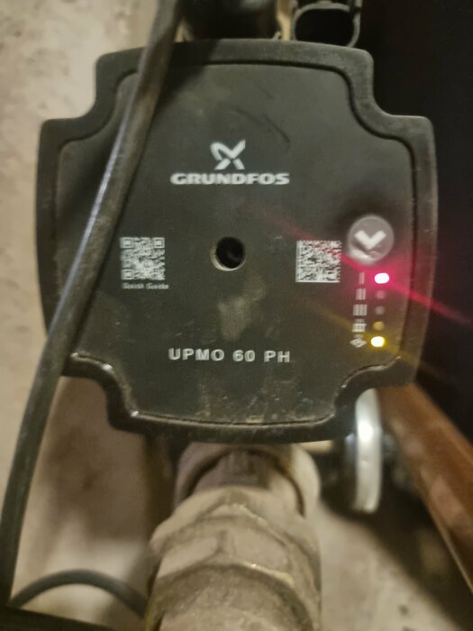 Grundfos cirkulationspump UPMO 60 PH med lysande LED-lampor, del av vedeldningssystem.