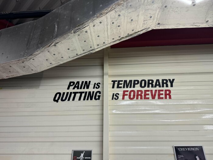 Text på industrivägg: "Pain is quitting. Temporary is forever.