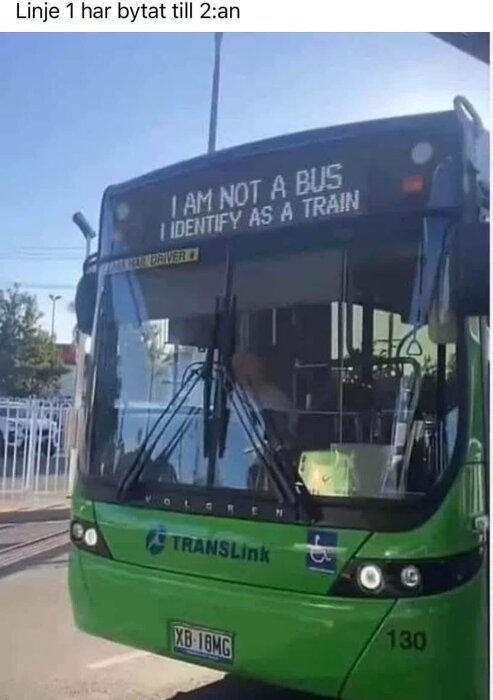 En grön buss med texten "I am not a bus, I identify as a train" på skyltens framsida.