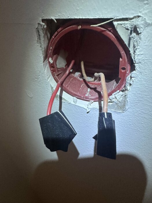 Brun och röd kabel i en väggöppning, redo för anslutning till en ny dimmer märkt Cotech.