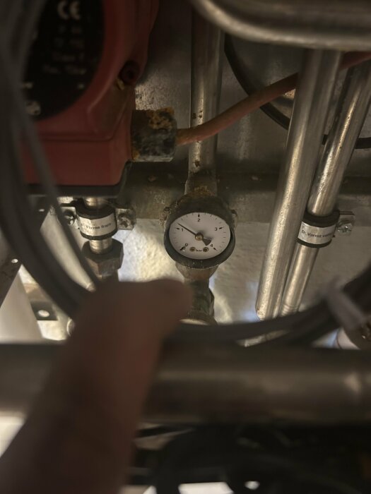 Mätare som visar tryck omkring 1 bar i ett rörsystem.