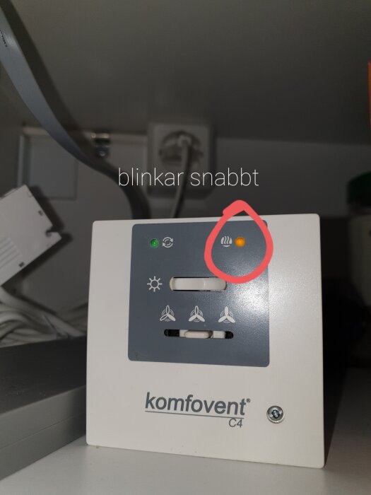 Kontrollpanel för Komfovent C4 med fyra indikatorlampor, varav en orange lampa blinkar snabbt.