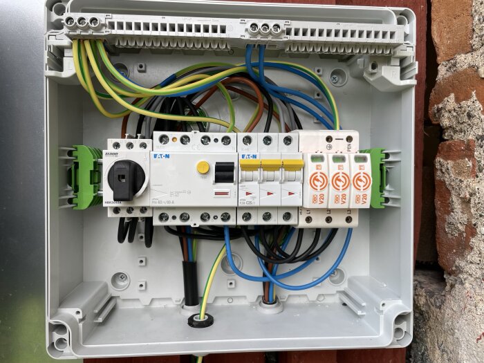 Elcentral med kopplingsplintar, tre gula 25A normbrytare och flera kablar anslutna. Placering i en fastighet med solcellsanläggning.
