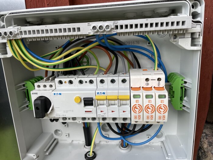 Elektrisk undercentral med tre gula 25A normbrytare och flera färgade kablar anslutna, installerad för anslutning av solceller och eventuell Homevolt-enhet.