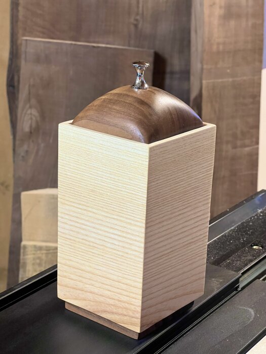 Träburk med lock av mörkare trä och silverknopp, används för chokladpraliner.