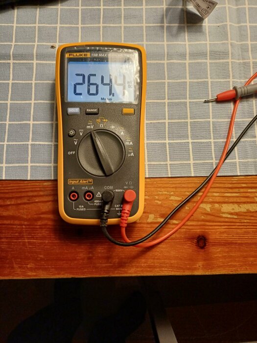 Fluke multimeter på ett bord, visar 264.4 mV DC på displayen.