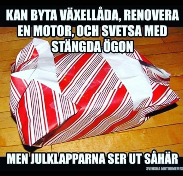 Julklapp inslagen i skrynkligt röd- och vitrandigt papper, med humortext om praktiska färdigheter och inslagning.