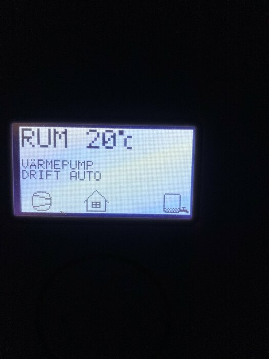 Display på bergvärmepanna visar "Rum 20°C", "Värmepump Drift Auto" och ikoner, där en ikon verkar ofullständig.