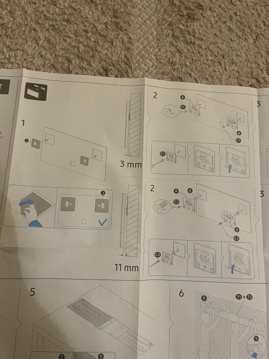 Instruktionspapper för montering av Samsung The Frame TV på väggen, med stegvisa illustrationer som visar hur skruvar och upphängningsdetaljer ska fästas.