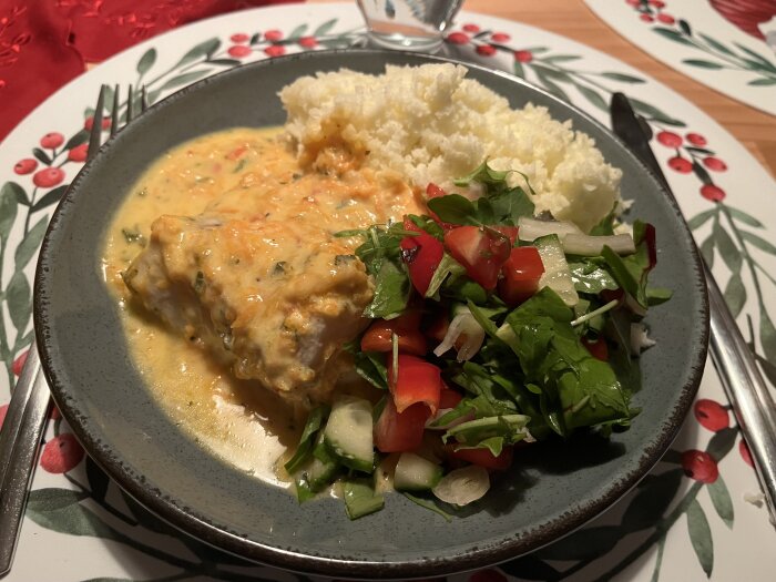 Krämig sweetchili torsk i ugn med pressad potatis och sallad, serverad på en tallrik med dekorativ duk.