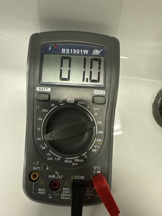 Multimeter BS1901W visar 0,1 ohm inställd på 200 ohm, mäter motstånd i ett badrumsuttag.