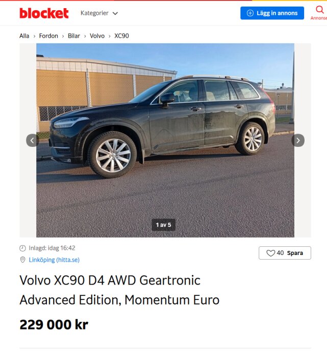 Svart Volvo XC90 D4 AWD Geartronic Advanced Edition parkerad på en asfalterad yta framför en byggnad.