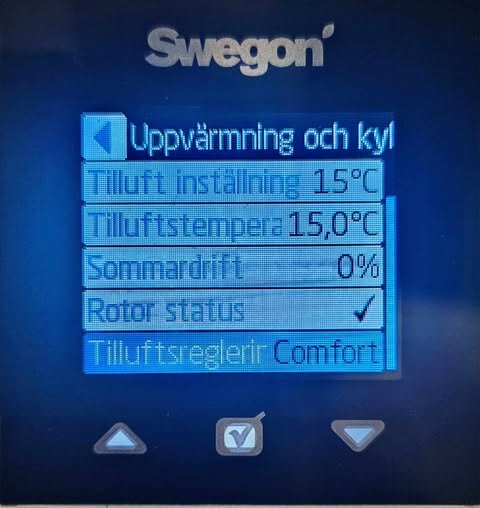 Display från Swegon-system visar tilluft inställning och temperatur på 15°C, sommardrift 0%, rotorstatus och tilluftsreglering i comfortläge.