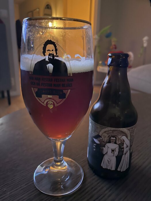 Ett glas med rödbrun julöl bredvid en flaska med etikett föreställande nunnor.