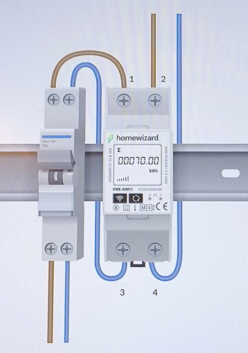 Installera elmätare efter säkring, inkopplad med bruna och blå kablar. Display visar 70 kWh. Fråga om rätt anslutning av nollan.