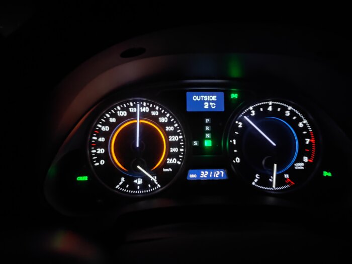 Bilde av bilens instrumentpanel med hastighetsmätare som visar orange ring vid 130 km/h, temperaturdisplay visar utetemperatur på 2°C.