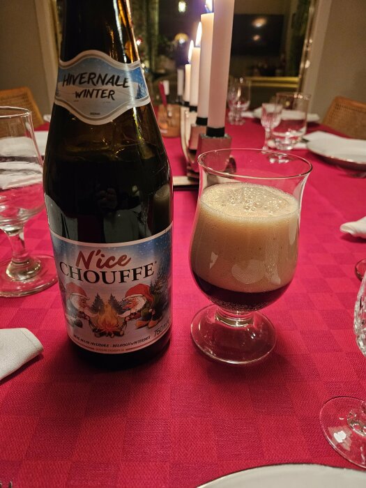 Belgisk vinteröl "N'ice Chouffe" på ett juldekorerat bord med röda dukar och tända ljus.