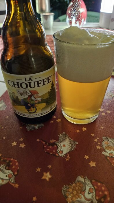 Flaska och glas med La Chouffe-öl på juligt dukat bord.