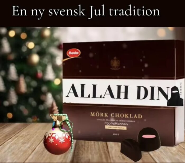 En chokladask märkt "Allah Din" framför en julgran, med en julkula och chokladpraliner på ett bord.