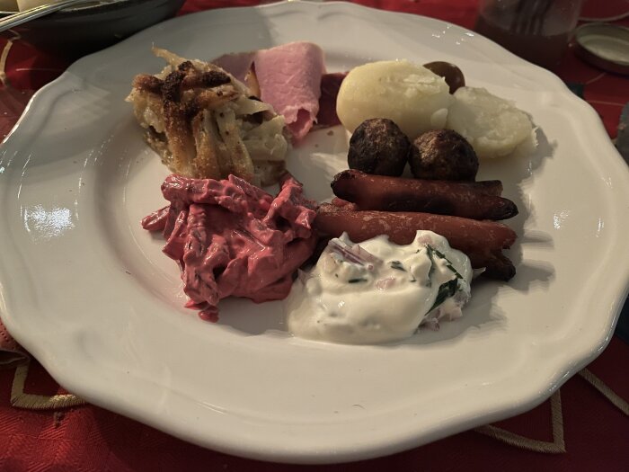 Jultallrik med prinskorv, köttbullar, rödbetssallad, potatis, senapssill och Jansson.