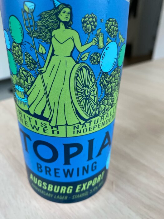 Blå och grön etikett på burk från Topia Brewing, Augsburg Export, med illustration av en kvinna som håller en ölsejdel omgiven av humle och andra motiv.