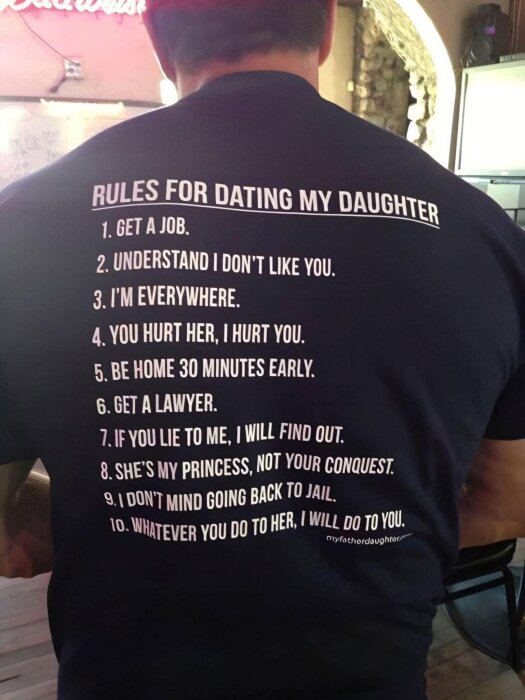 En man bär en t-shirt med texten "Rules for Dating My Daughter" följt av 10 humoristiska regler om att dejta hans dotter.