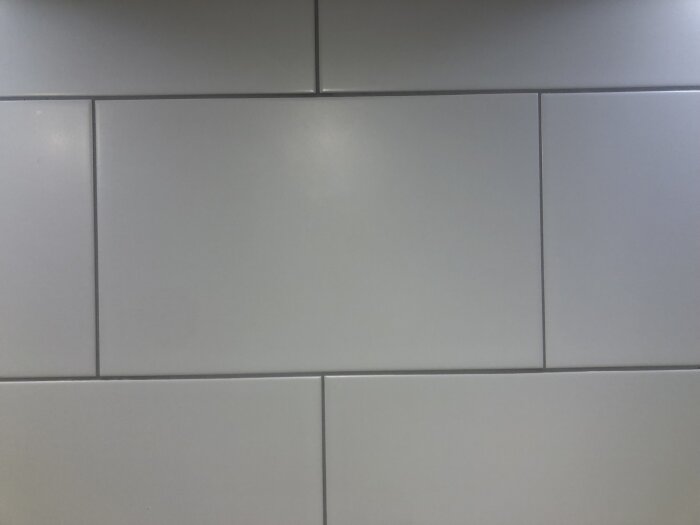 Kakelplattor med ojämn fogbredd och skevhet i kakelsättning.