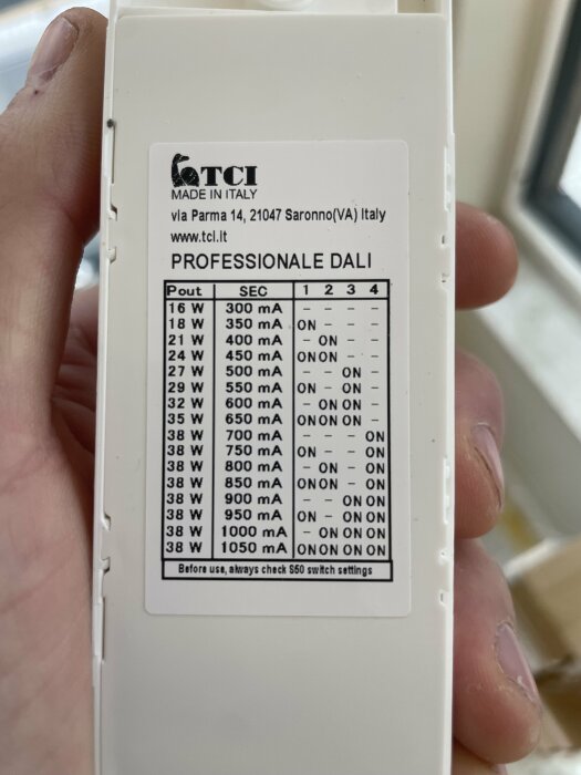 Hand håller ett drivdon från TCI med en etikett som visar effekt och strömstyrka i watt och mA.