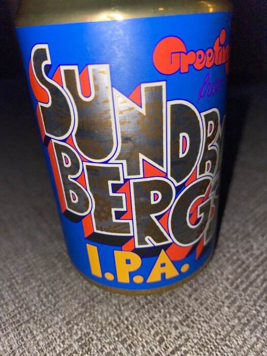 En närbild på en ölburk av Omnipollo Sundbybergs IPA med blå och orange etikett.
