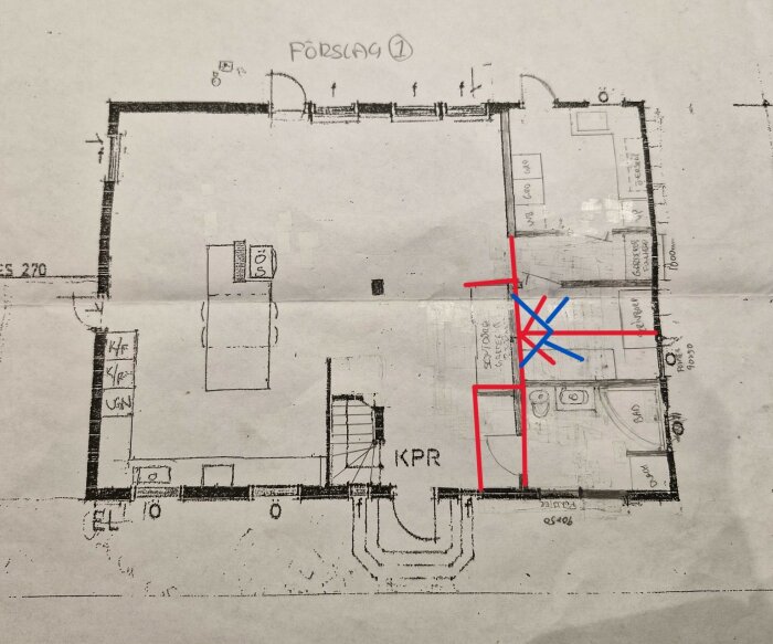 Byggnadsritning över planlösning med badrum och garderober markerade, inklusive blå och röda linjer för avskiljning.