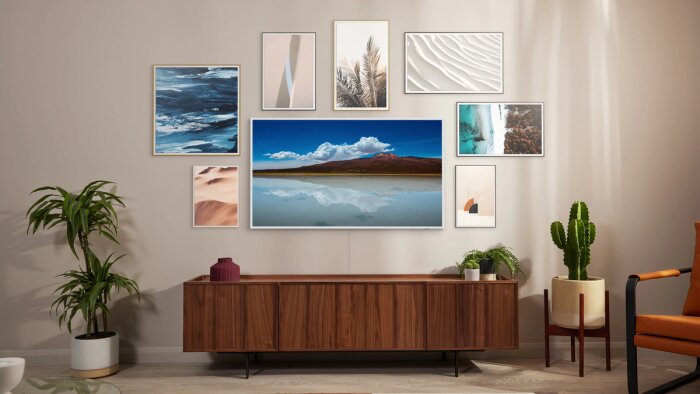 Vardagsrum med TV:n The Frame som visar landskapsbild, omgiven av konstverk, träskänk, växter och modern inredning.