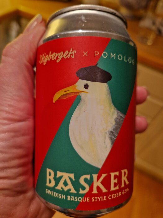 Stigbergets ciderburk med måsmotiv i fransk stil, text Basker och alkoholhalt 6,9%, hålls i en hand.