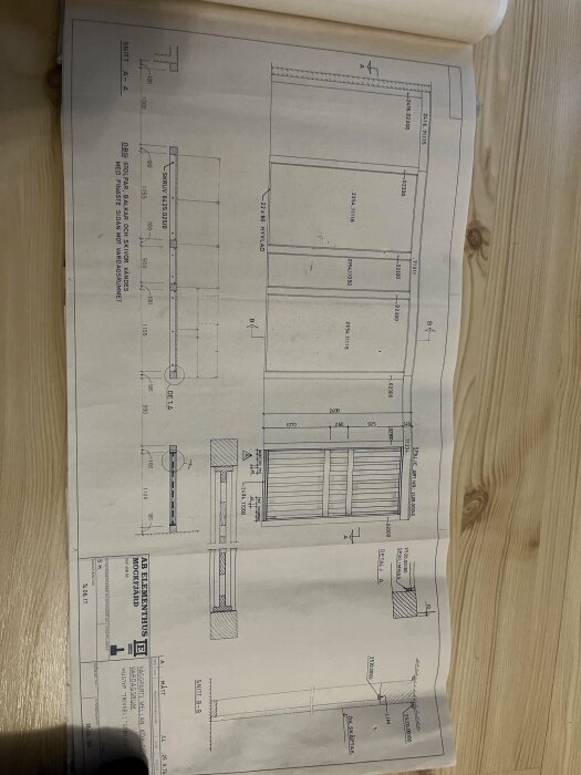 Byggnadsritningar som visar detaljer för en gul vägg och en vägg vid en trappa, med mått och tvärsektioner på träpålar och skivor.