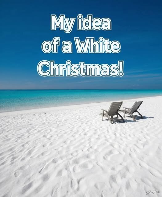 Två solstolar på en vit sandstrand vid turkost hav med texten "My idea of a White Christmas!".