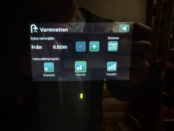 Displayinställningar för varmvatten, med alternativ för "Ekonomi", "Normal" och "Komfort". Det visar för närvarande programmet "Normal".