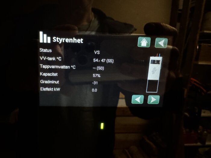 Bild av kontrollpanelens display, visar mätvärden för värmepump: status VS, kapacitet 57%, VV-tank 54/47°C, inga eleffekt eller tappvarmvatten.
