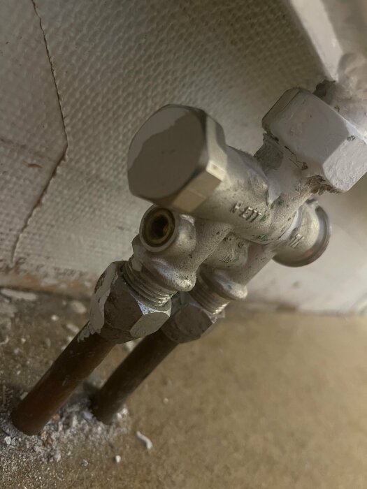 Radiatorrör och ventil med insex-nyckel och plugg i källare, diskussion om avstängning och återkoppling under renovering.