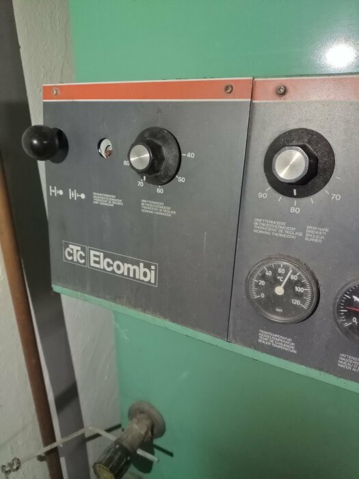 Kontrollpanel på en CTC Elcombi värmepanna med flera vred och temperaturmätare.