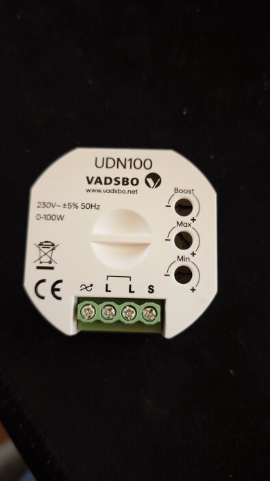 Bild på en Vadsbo UDN100 dimmer med inställningar för boost, max och min samt anslutningsterminaler på en svart bakgrund.