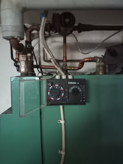 Pannrum med rörsystem och en styrpanel på en grön panna.