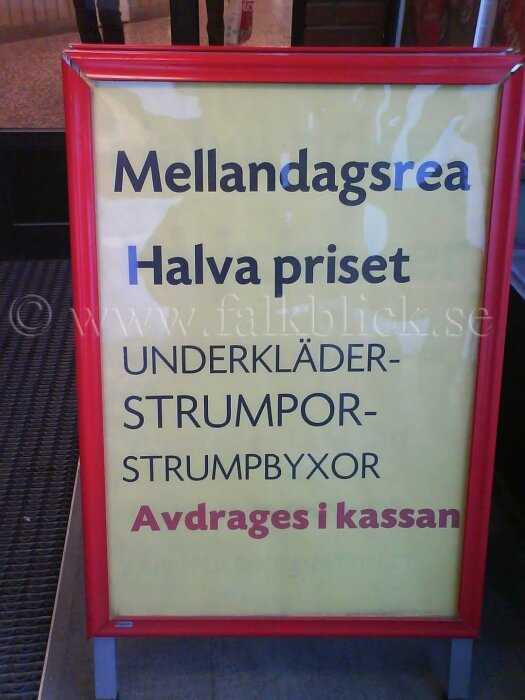 Reklamskylt för mellandagsrea med halva priset på underkläder, strumpor och strumpbyxor, avdraget i kassan.