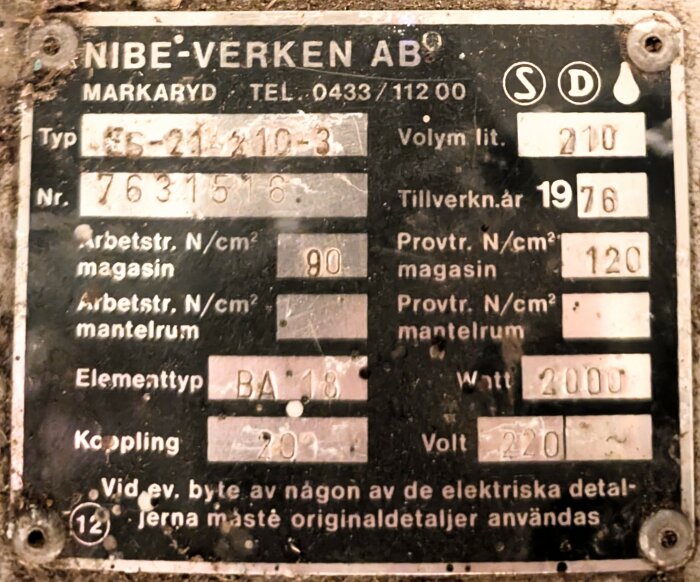 Typskylt från en gammal Nibe ES varmvattenberedare, tillverkad 1976, visar specifikationer som typnummer ES-21 210-3 och elementtyp BA 18.