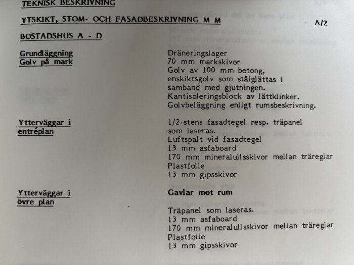 Teknisk beskrivning av byggnadens konstruktion och material, inklusive dräneringslager, golv och ytterväggar med specifikationer.